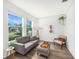Cozy living room with a comfortable sofa, a large window with a view, and wood-look tile flooring at 672 Old Windsor Way, Spring Hill, FL 34609