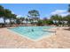 Community swimming pool on a sunny day surrounded by trees and lounge chairs at 672 Old Windsor Way, Spring Hill, FL 34609