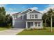 Charming two-story home featuring a gray exterior, well-manicured lawn, and tropical landscaping at 6737 Flint Creek Dr, Land O Lakes, FL 34638