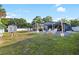 Large grassy yard with stone firepit area, covered patio and dining, storage shed, and mature trees at 6907 W Creek Dr, Tampa, FL 33615