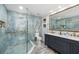 Modern bathroom with glass shower, blue marbled tiling, and a vanity with double sinks at 6907 W Creek Dr, Tampa, FL 33615