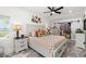 Bright bedroom featuring a patterned bedspread, dual nightstands, and closet with sliding barn door at 6907 W Creek Dr, Tampa, FL 33615
