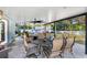 Relax on the covered patio with ceiling fan, dining, and plush seating, overlooking the large fenced in backyard at 6907 W Creek Dr, Tampa, FL 33615