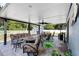 Entertain on the covered patio with ceiling fan, plush seating, and dining, with view of storage shed at 6907 W Creek Dr, Tampa, FL 33615