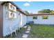 Exterior view of the side yard of home with mini-split AC systems and cozy seating at 6907 W Creek Dr, Tampa, FL 33615