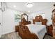 Bright main bedroom with hardwood floors, dresser, and large windows at 6907 W Creek Dr, Tampa, FL 33615