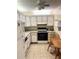 Functional kitchen with white cabinetry, appliances, and a small table, offering a practical space for meal preparation at 7645 Sun Island S Dr # 306, South Pasadena, FL 33707