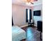 Bedroom with wood-look flooring, dark window coverings, a wall-mounted TV, and LED lights at 8004 25Th W Ave, Bradenton, FL 34209