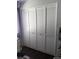 Bedroom closet featuring white louvered doors for a neat and organized storage solution in the bedroom at 8004 25Th W Ave, Bradenton, FL 34209