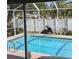 Relaxing pool view through a screened-in enclosure and a lush green yard at 8004 25Th W Ave, Bradenton, FL 34209