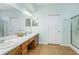 Well-lit bathroom with double sinks, a large mirror, and a glass-enclosed shower, providing ample space at 8116 Sanguinelli Rd, Land O Lakes, FL 34637