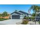 Charming single-story home with a two-car garage, well-manicured lawn, and an American flag at 8116 Sanguinelli Rd, Land O Lakes, FL 34637