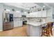 Well-lit kitchen features white cabinets, stainless steel appliances, and a countertop island with bar seating at 8116 Sanguinelli Rd, Land O Lakes, FL 34637