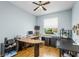 Functional home office with wood flooring, multiple desks, and bright natural light from the window at 8116 Sanguinelli Rd, Land O Lakes, FL 34637