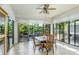 Bright sunroom with tile flooring, large windows offering scenic views, and comfortable dining set at 8116 Sanguinelli Rd, Land O Lakes, FL 34637