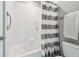 This bathroom features a shower/tub, tile walls, hand rails and grab bars at 8227 Bird Whistle Ln, Land O Lakes, FL 34637