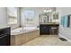 Bathroom featuring a corner tub, vanity with granite countertops, and a large window at 8227 Bird Whistle Ln, Land O Lakes, FL 34637
