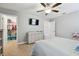 Bedroom with carpeted floor, ceiling fan, dresser, and an adjoining walk-in closet at 8227 Bird Whistle Ln, Land O Lakes, FL 34637
