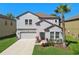 Charming two-story home featuring a well-maintained lawn, two car garage and a lovely palm tree at 8227 Bird Whistle Ln, Land O Lakes, FL 34637