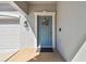 Inviting front door with a decorative wreath, sidelight, and a covered porch entryway at 8227 Bird Whistle Ln, Land O Lakes, FL 34637