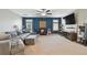 Upstairs living room featuring a sectional sofa, plush carpeting, ceiling fan, and wall mounted TV at 8227 Bird Whistle Ln, Land O Lakes, FL 34637