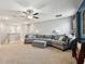 Spacious living room with plush carpeting, neutral walls, ceiling fan, and comfortable seating at 8227 Bird Whistle Ln, Land O Lakes, FL 34637