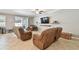 Cozy living room featuring reclining chairs, neutral walls and flooring, and sliding glass doors to the exterior at 8227 Bird Whistle Ln, Land O Lakes, FL 34637