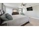 Spacious main bedroom featuring neutral colors, a ceiling fan, and a mounted television at 8227 Bird Whistle Ln, Land O Lakes, FL 34637