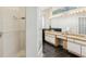 A bright bathroom boasts a double vanity, large mirror, and a tiled shower with glass block at 915 Live Oak Ne Ter, St Petersburg, FL 33703