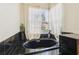 A bathroom showcasing a black tile soaking tub next to a window with white curtains at 915 Live Oak Ne Ter, St Petersburg, FL 33703