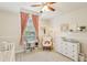 This Bedroom features a rocking chair, dresser and window with peach colored curtains at 915 Live Oak Ne Ter, St Petersburg, FL 33703