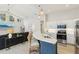 Modern kitchen featuring white cabinets, stainless appliances, marble countertops, and adjacent living area at 915 Live Oak Ne Ter, St Petersburg, FL 33703