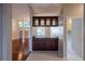 Bar counter with dark cabinets and a light-colored tile floor between the entry and a hallway at 9159 Highland Ridge Way, Tampa, FL 33647