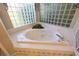 Inviting bathroom with a jetted tub and beautiful tile surround at 9159 Highland Ridge Way, Tampa, FL 33647
