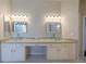 Bright bathroom featuring double sinks with glass bowls, a vanity, and neutral tile flooring at 9159 Highland Ridge Way, Tampa, FL 33647