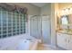 Bathroom featuring a glass block window, soaking tub, and glass-enclosed shower at 9159 Highland Ridge Way, Tampa, FL 33647