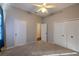 Spacious carpeted bedroom with ceiling fan, and double door closet for ample storage space at 9159 Highland Ridge Way, Tampa, FL 33647