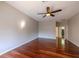 Spacious bedroom featuring a ceiling fan and rich hardwood flooring throughout at 9159 Highland Ridge Way, Tampa, FL 33647