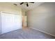 Bedroom featuring neutral carpet, a closet with sliding doors and a ceiling fan at 9159 Highland Ridge Way, Tampa, FL 33647