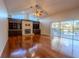 Bright living room with hardwood floors, built-in shelving, fireplace, and sliding glass doors to the pool area at 9159 Highland Ridge Way, Tampa, FL 33647