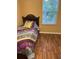 Bedroom featuring wood floors, window, and a twin bed at 9508 Ashburn Creek Ln, Tampa, FL 33610