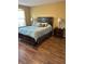 Primary bedroom featuring wood floors, large window, and spacious layout at 9508 Ashburn Creek Ln, Tampa, FL 33610