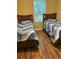 Bedroom features two twin beds with dark wood flooring at 9508 Ashburn Creek Ln, Tampa, FL 33610