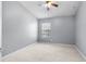 Neutral bedroom features a ceiling fan and a window overlooking the yard, and neutral carpet at 10212 Westpark Preserve Blvd, Tampa, FL 33625