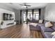 Bright living room with hardwood floors, ceiling fan and large sectional sofa, offering a relaxing space at 10212 Westpark Preserve Blvd, Tampa, FL 33625