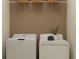 Functional laundry room with modern white washer and dryer units, and overhead storage at 10865 Rustic Eve Ct, Land O Lakes, FL 34638