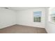 Bright bedroom with neutral carpet and a window offering natural light at 12466 Gust Ct, Hudson, FL 34669