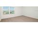 Bright bedroom with neutral carpet and a window offering natural light at 12466 Gust Ct, Hudson, FL 34669