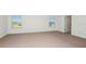 Spacious carpeted bedroom with bright natural light from large windows at 12466 Gust Ct, Hudson, FL 34669