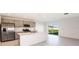 Bright kitchen with island, modern appliances, gray cabinets, and sliding glass doors to the backyard at 12466 Gust Ct, Hudson, FL 34669
